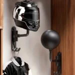 Väggmonterade kulformade hjälmhållare med en motorcykelhjälm och jacka upphängda